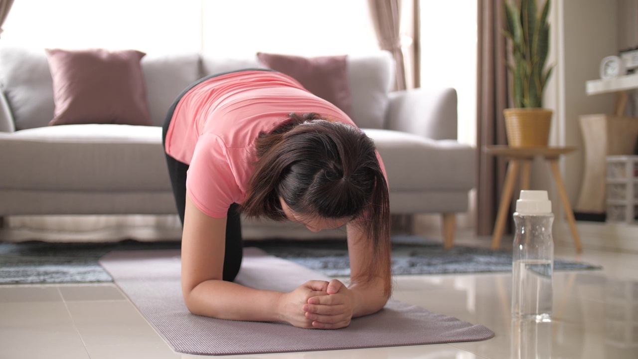 女人在家里的客厅里锻炼视频素材