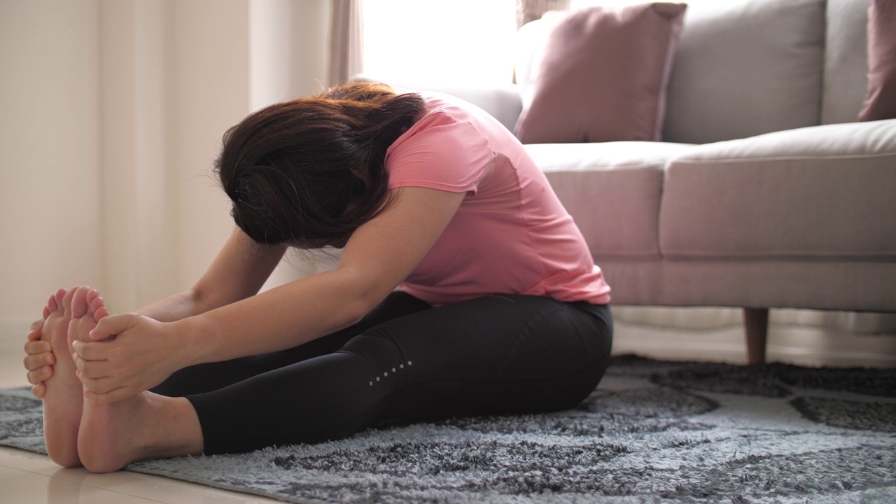 女人在家里的客厅里锻炼视频素材