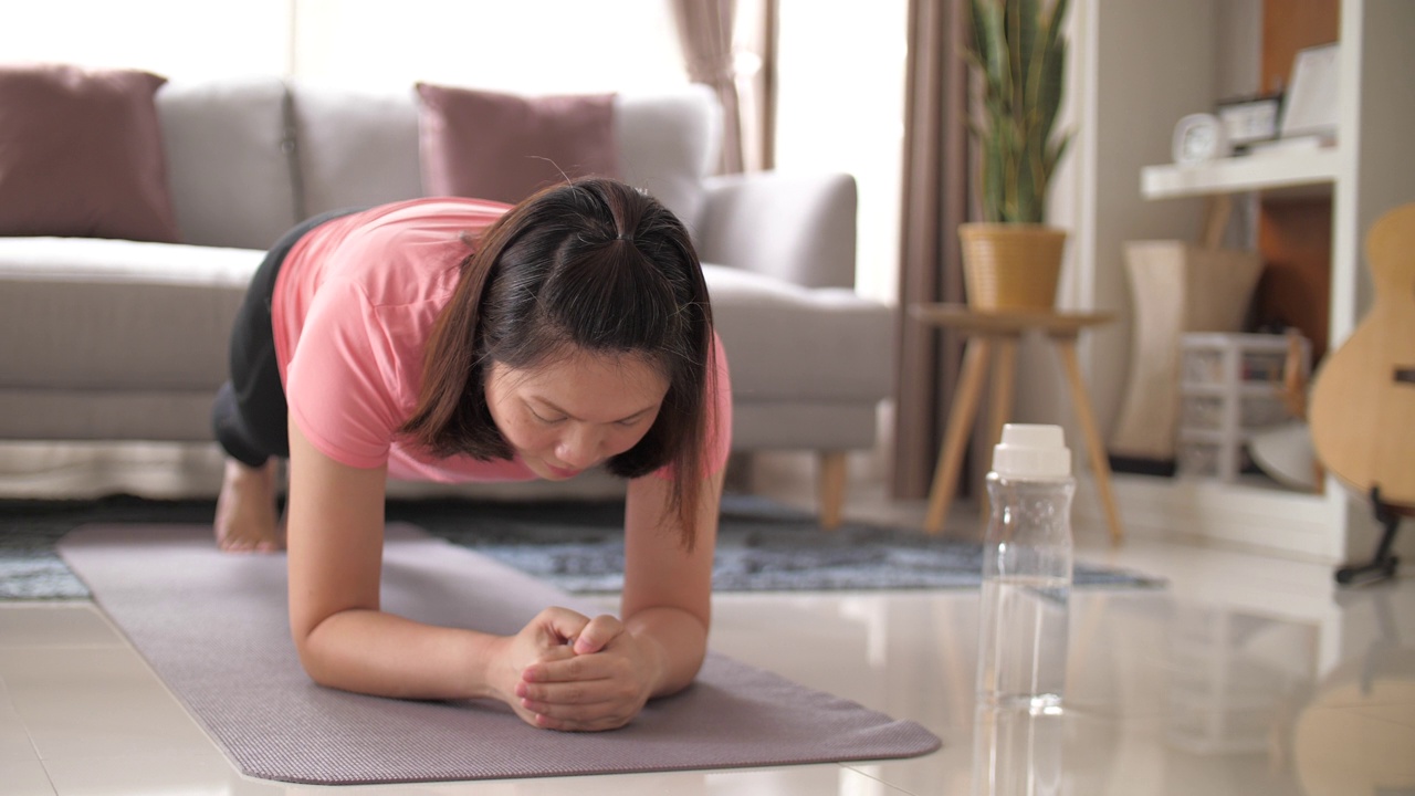 女人在家里的客厅里锻炼视频素材