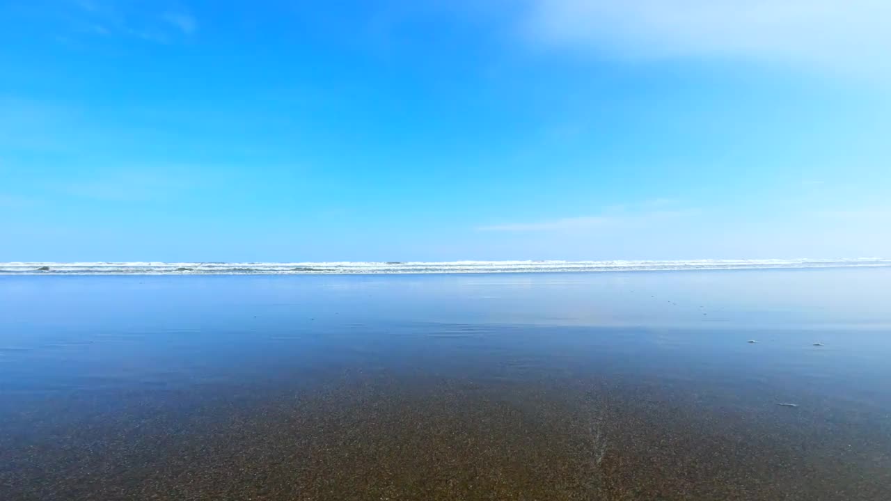 飞溅的波浪在海滩上。海浪拍打着相机视频素材