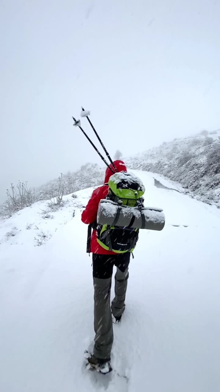 冬天背着背包在山里徒步旅行的人视频素材