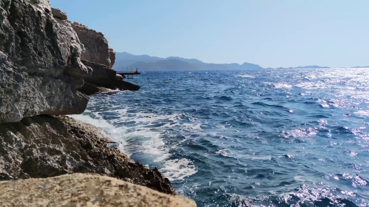 慢慢地，海浪拍打着悬崖，溅起许多水花和泡沫视频素材