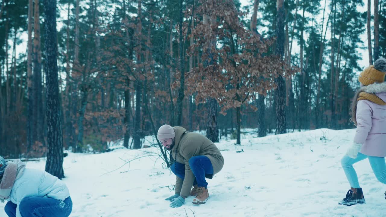 女儿和父母在森林里玩雪球视频素材