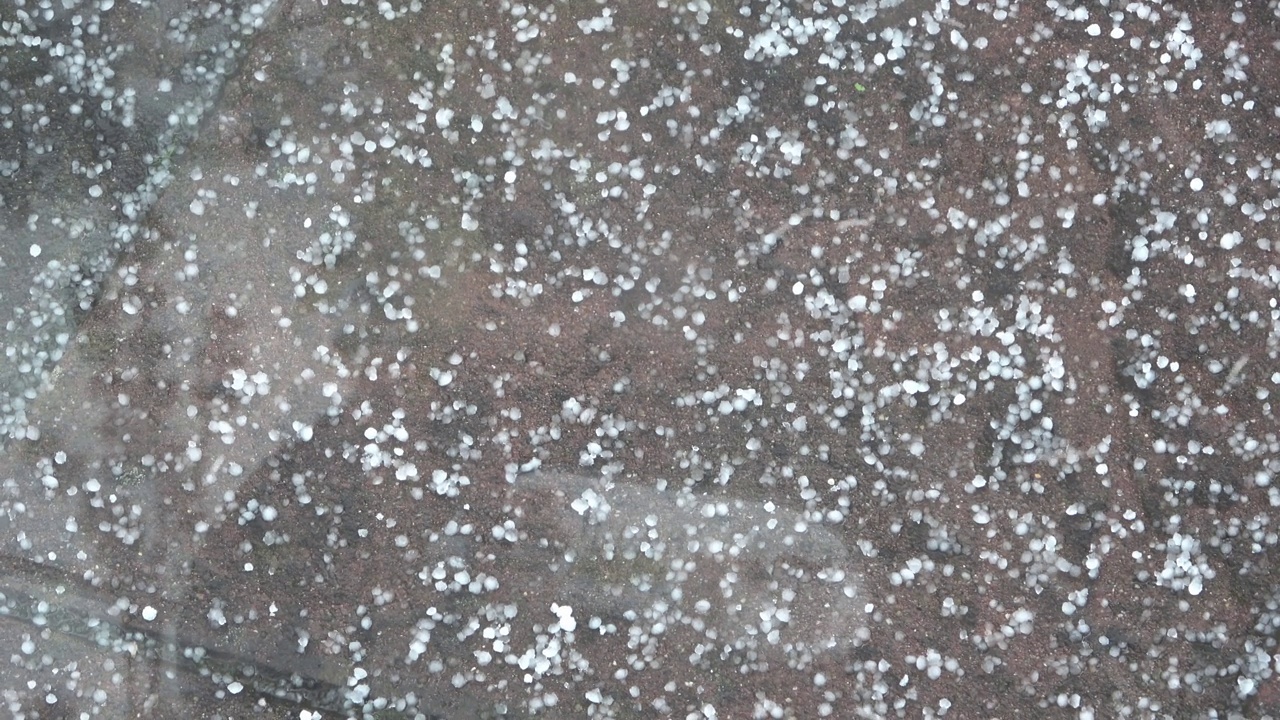 沉重的冰雹在铺好的道路上-冰雹从地面上跳起来。视频素材