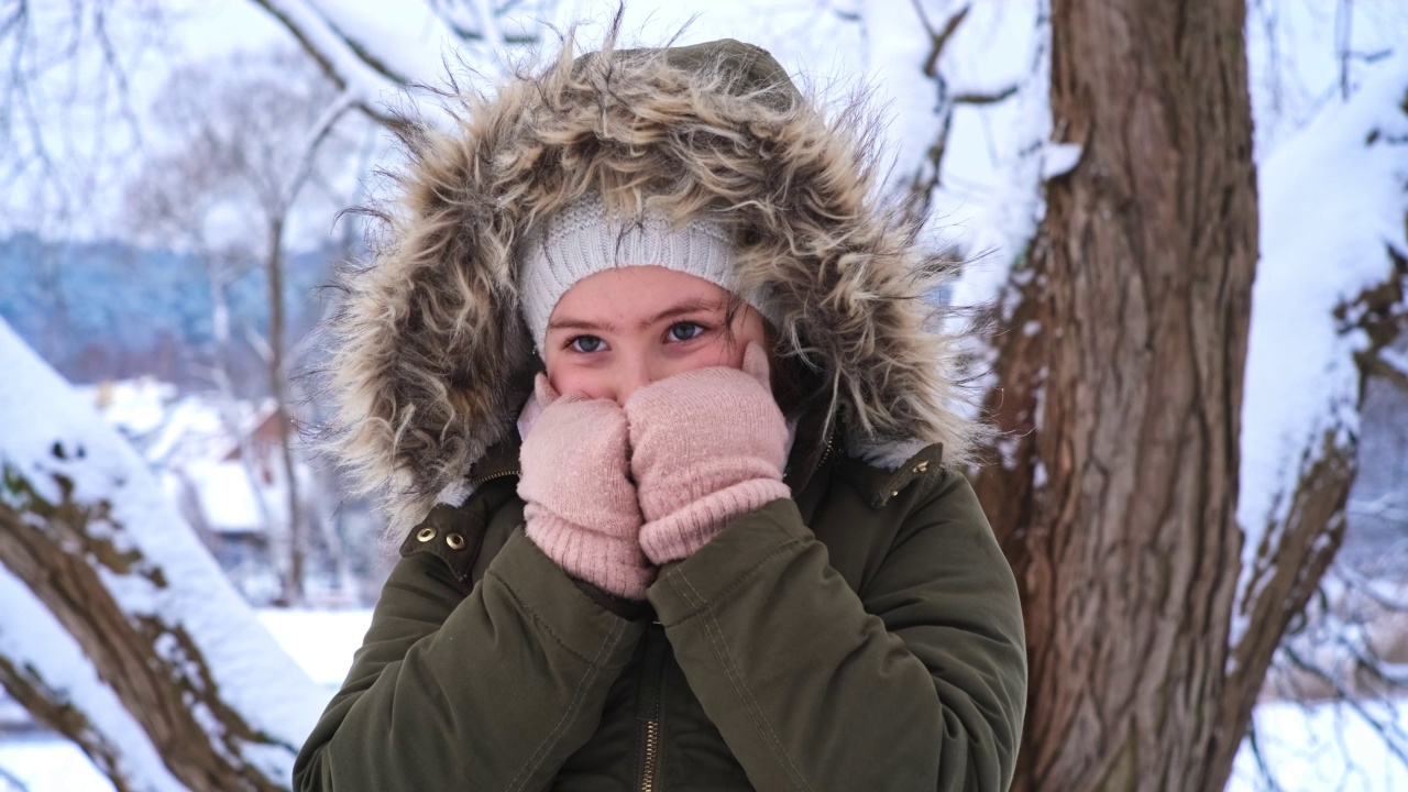 美丽的年轻高加索女孩在温暖的冬天夹克和手套站在户外寒冷的雪天视频素材