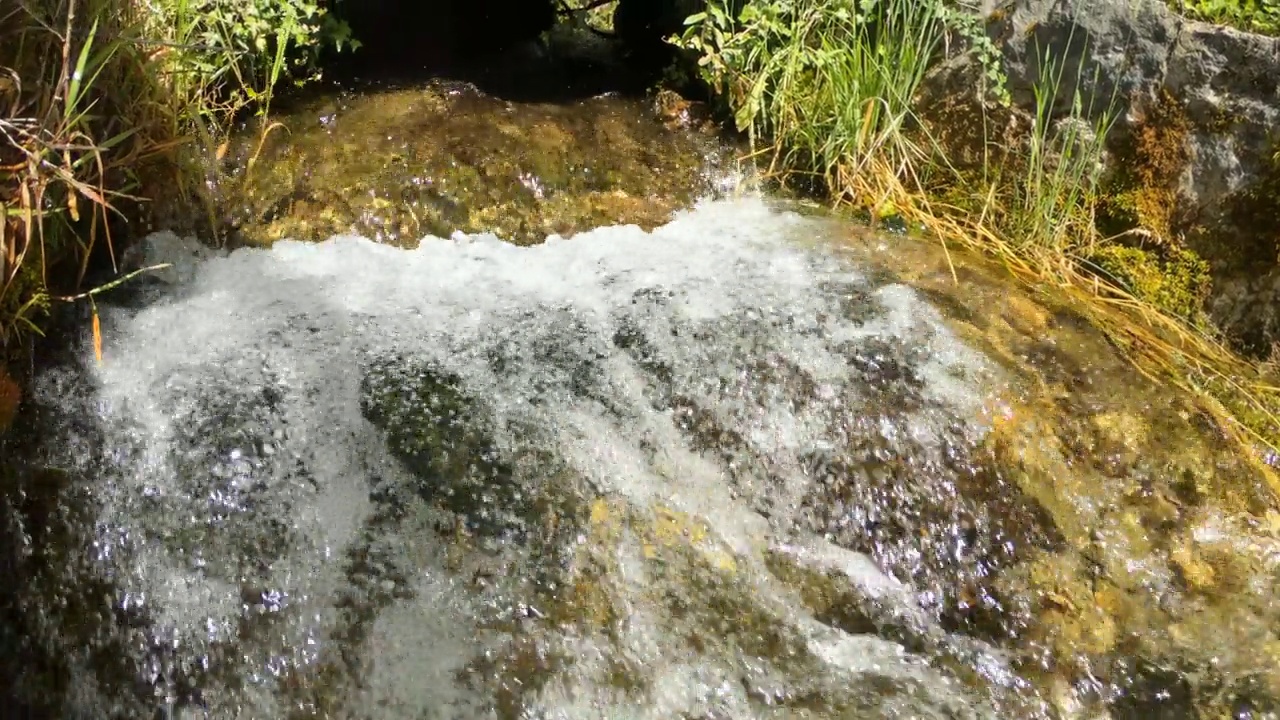 一条美丽的山溪流过石头，背景。清澈的水，自然，慢动作视频素材