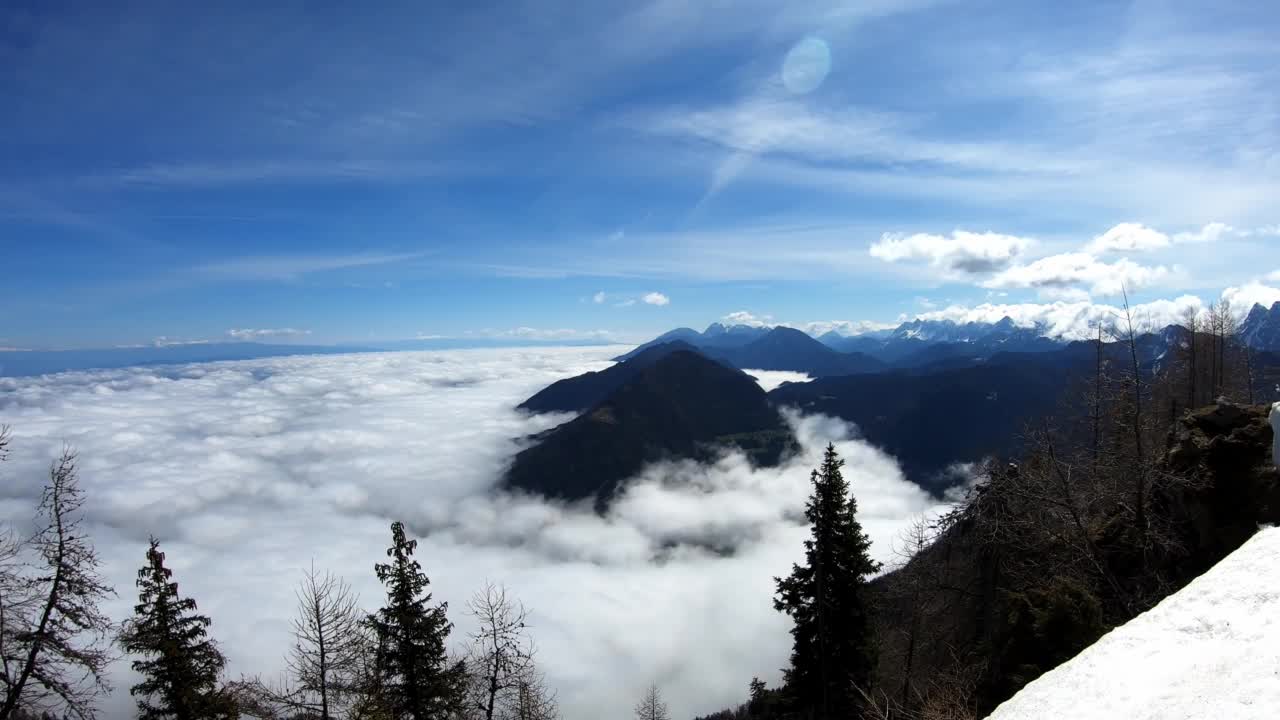 从奥地利卡林西亚卡拉万克斯的Matschacher Gupf山顶全景的时间推移。高山链部分被雪覆盖。晴朗的日子。山谷里有雾。云移动视频素材