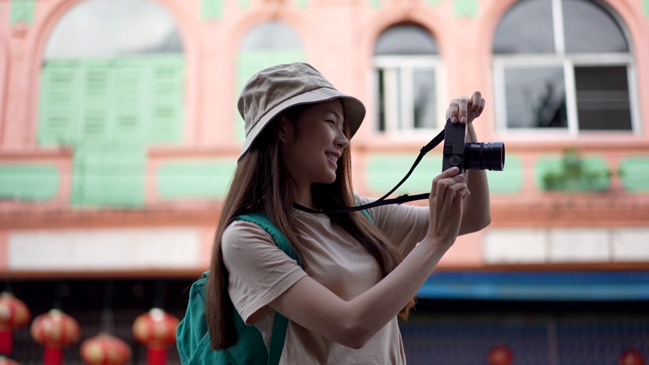 亚洲年轻女性背包客使用相机拍摄地点，同时旅行与快乐的情感表达，独自旅行在生活方式度假夏天。视频素材