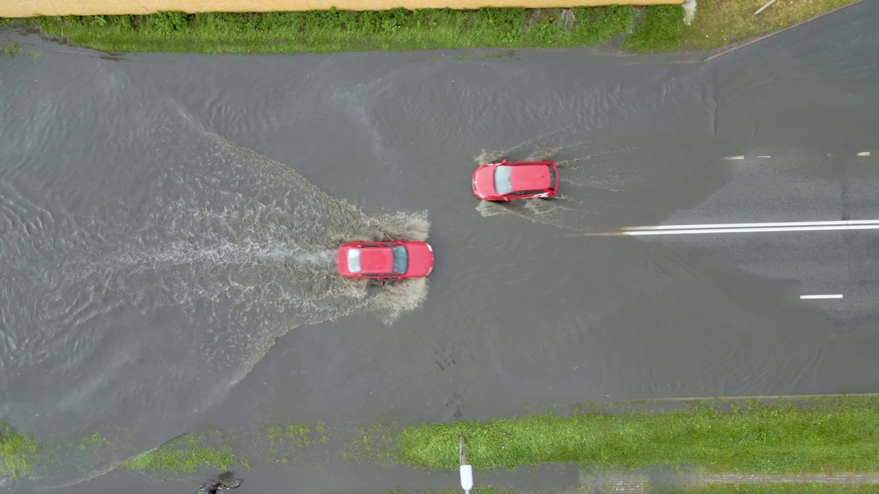 城市交通鸟瞰图，汽车行驶在暴雨后被淹没的街道上。道路排水系统的问题视频素材