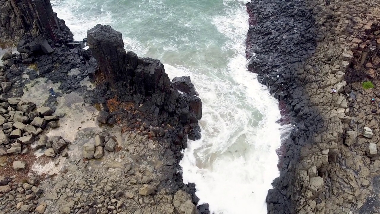 航拍海浪在玄武岩火山柱上破碎，背景与复制空间视频下载