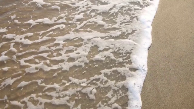 海水的泡沫在沙滩上视频素材