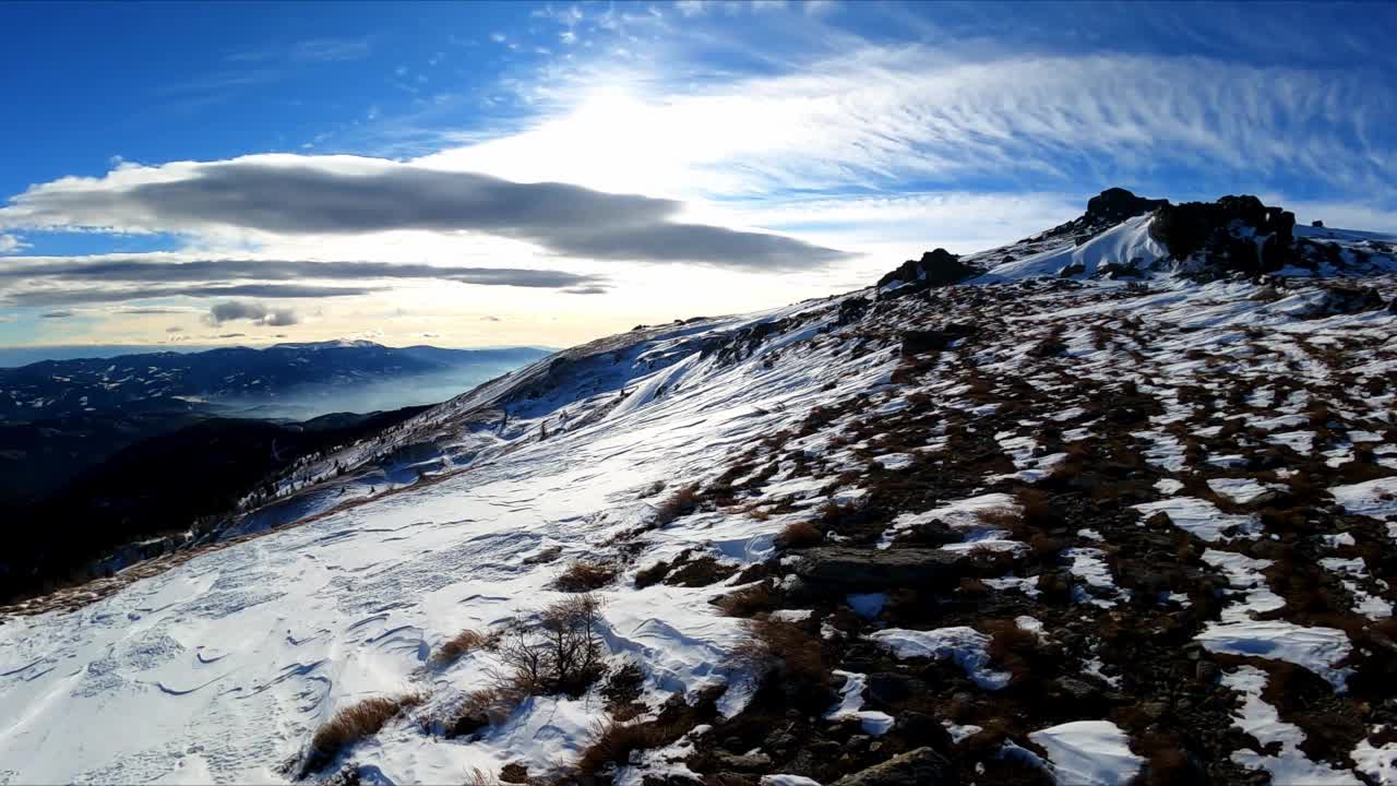 在奥地利卡林西亚和斯蒂里亚的拉万塔尔阿尔卑斯山，冬季积雪覆盖的高山草地上的一条徒步小路。高原地形在山区。冬季仙境。自由的概念。户外活动视频素材