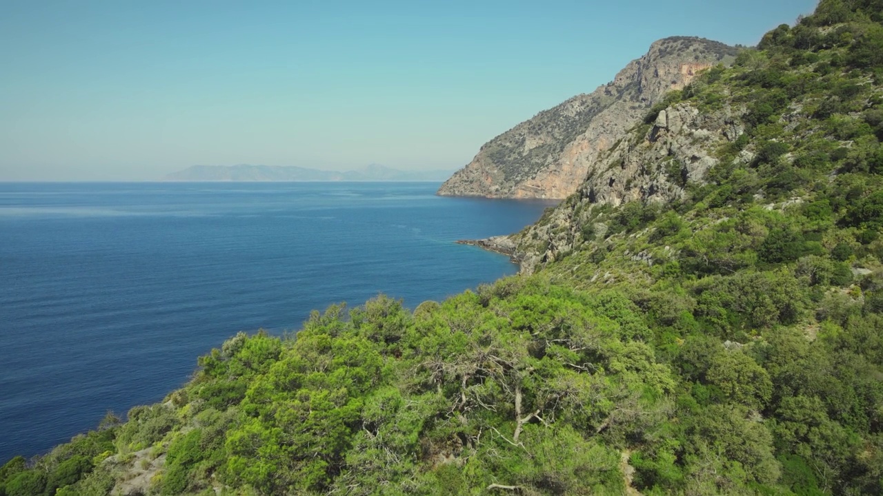 鸟瞰岩石嶙峋的海岸线，碧绿清澈的海水视频素材