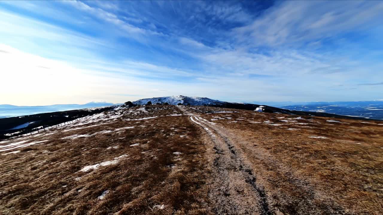 在奥地利卡林西亚和斯蒂里亚的拉万塔尔阿尔卑斯山，冬季积雪覆盖的高山草地上的一条徒步小路。高原地形在山区。冬季仙境。自由的概念。户外活动视频素材