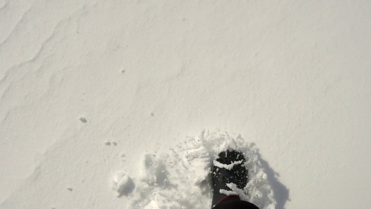 男人穿着冬靴走在雪地上。视频素材