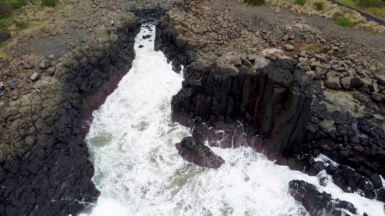 鸟瞰海浪拍打玄武岩火山柱视频下载