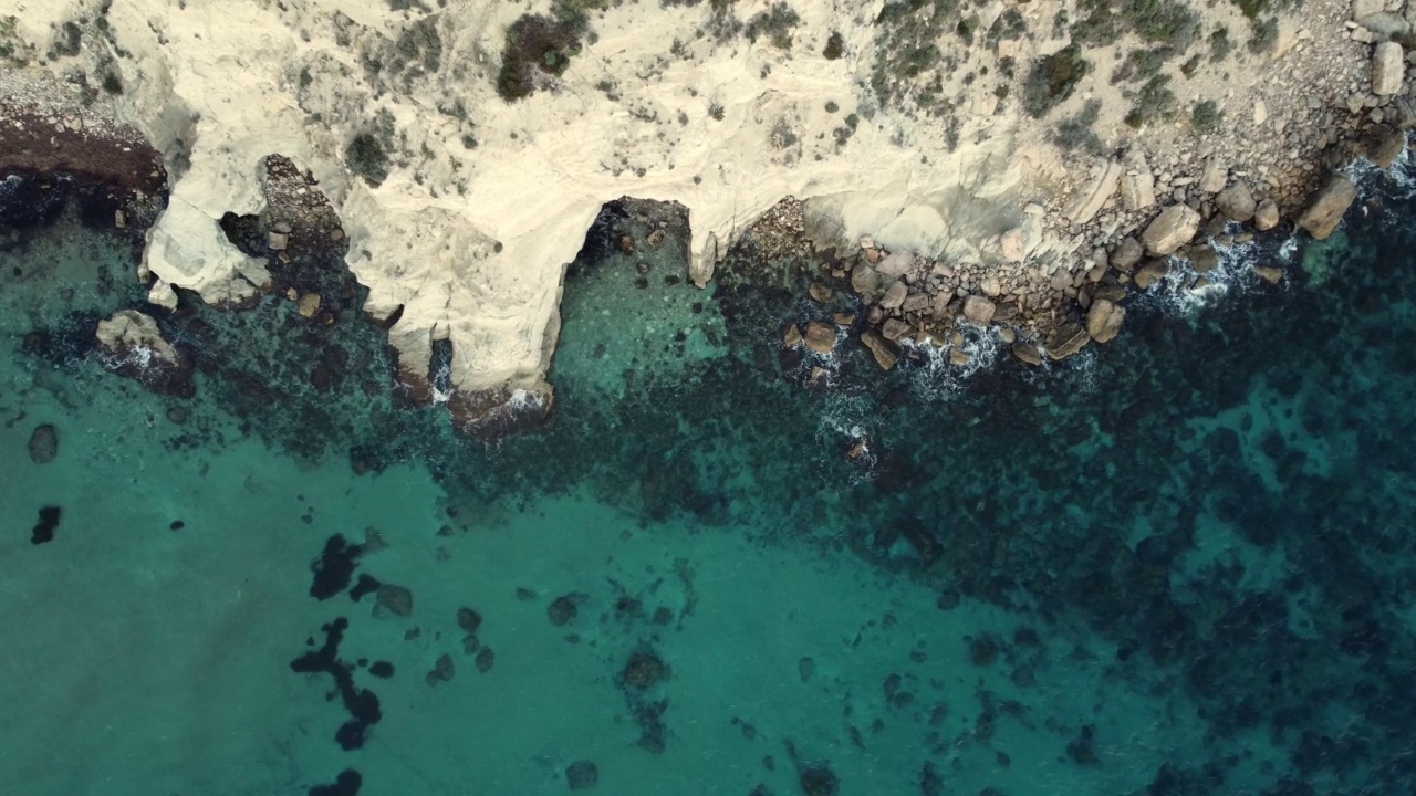 蓝色的海和黄色的岩石海滩的鸟瞰图。视频素材