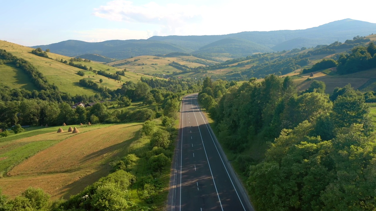 一架无人机飞过一条穿越山口的公路时所看到的壮丽景色。视频素材