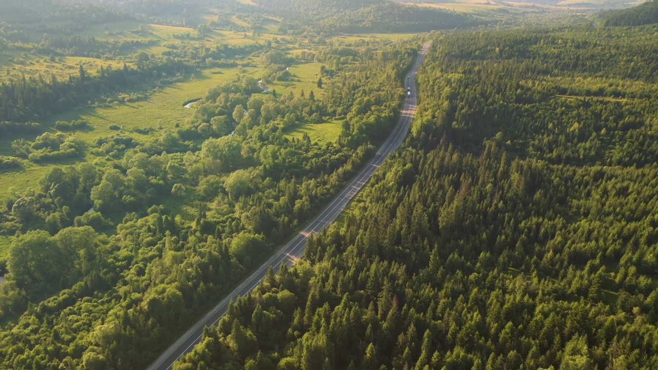 一架无人机飞过一条穿越山口的公路时所看到的壮丽景色。视频素材