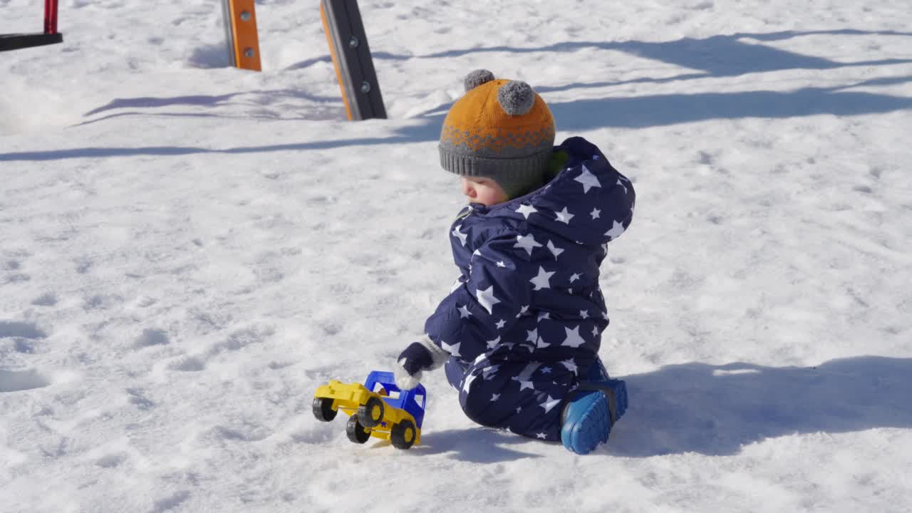 宝宝在冬天的雪地里玩耍1岁的小男孩在公园里散步。视频素材