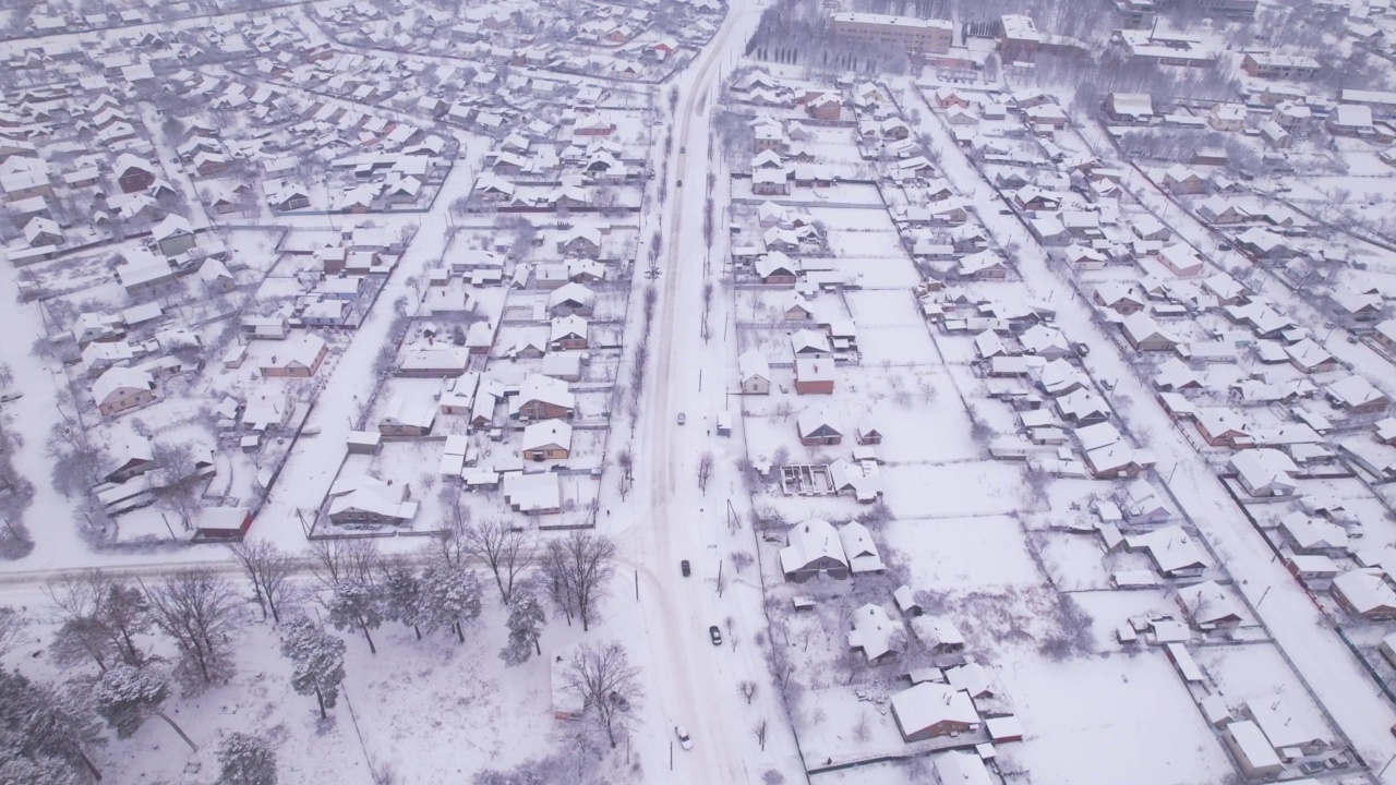 冬季鸟瞰图，雪村有私人住宅和花园地块视频素材