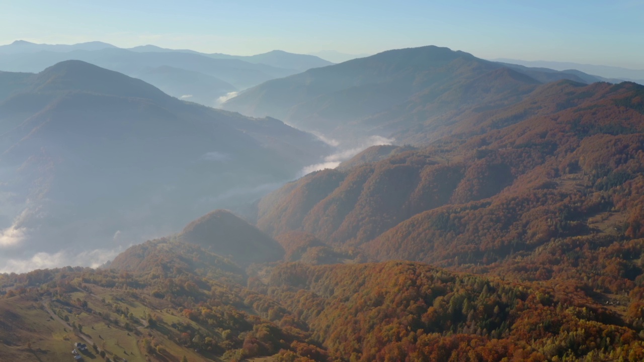 在一个阳光明媚的日子里，一架无人机飞过风景如画的秋山。视频素材