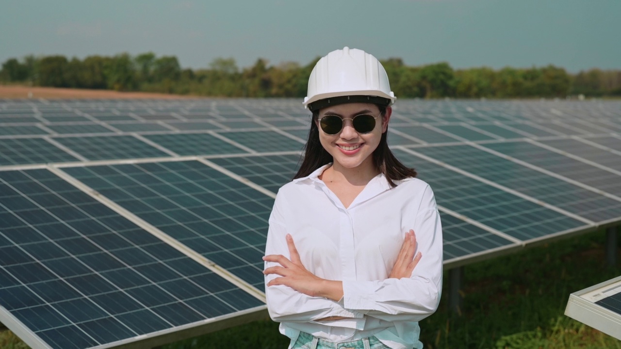 戴着头盔的女工程师在光伏电池场或太阳能电池板场，环保和清洁能源。视频素材