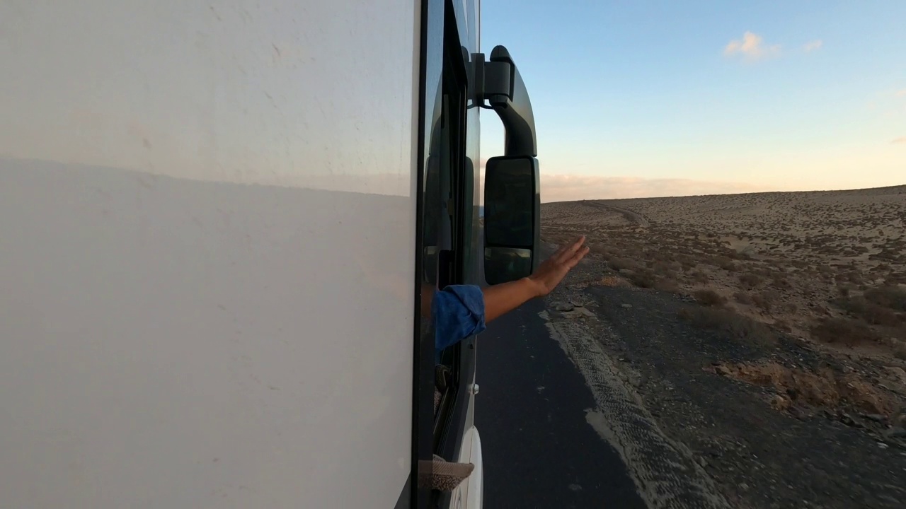 旅行和目的地概念与现代露营车。男人在寡妇外面玩风就像玩翅膀。人们乘坐面包车享受人生旅途冒险。长沥青路面背景视频素材