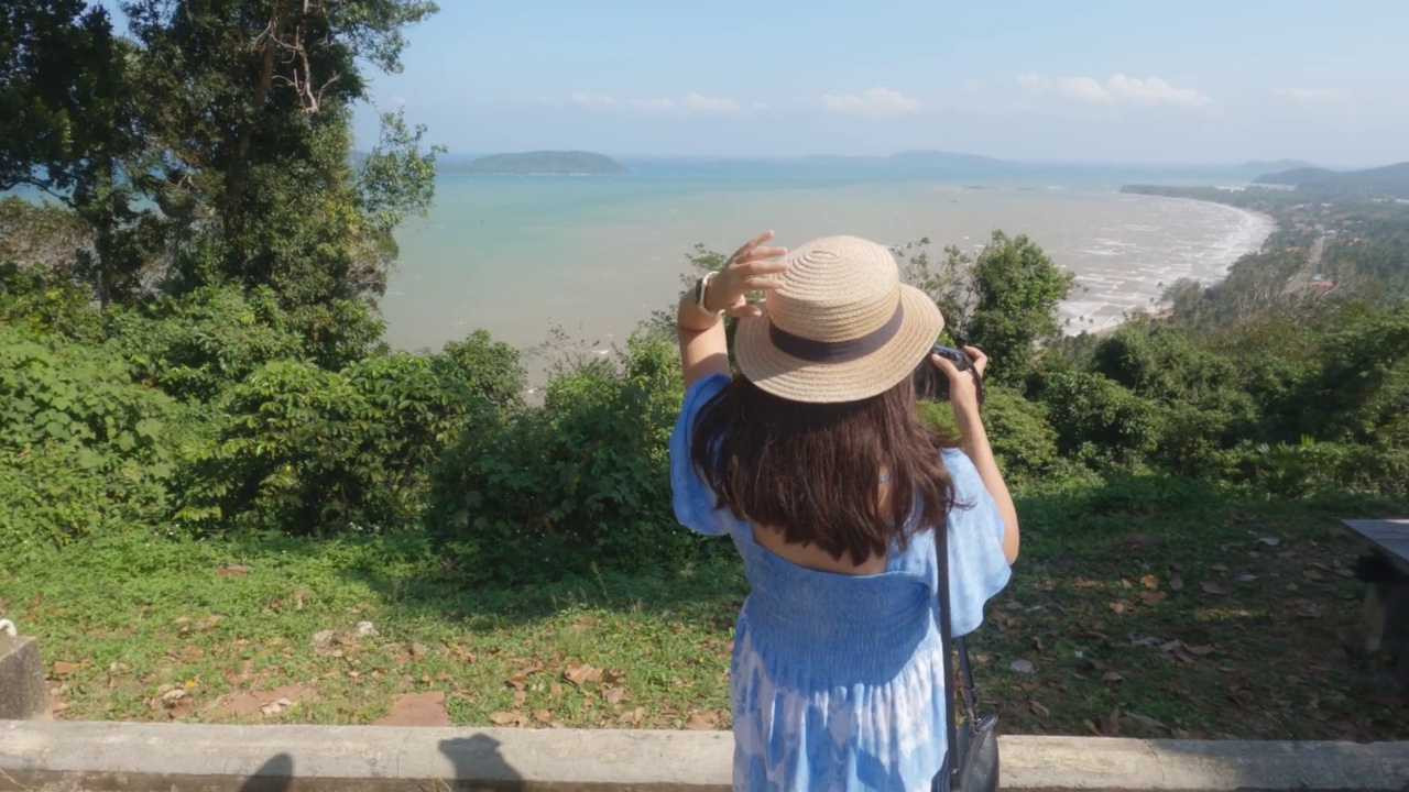 一个亚洲女人在海边的山上旅行。视频素材