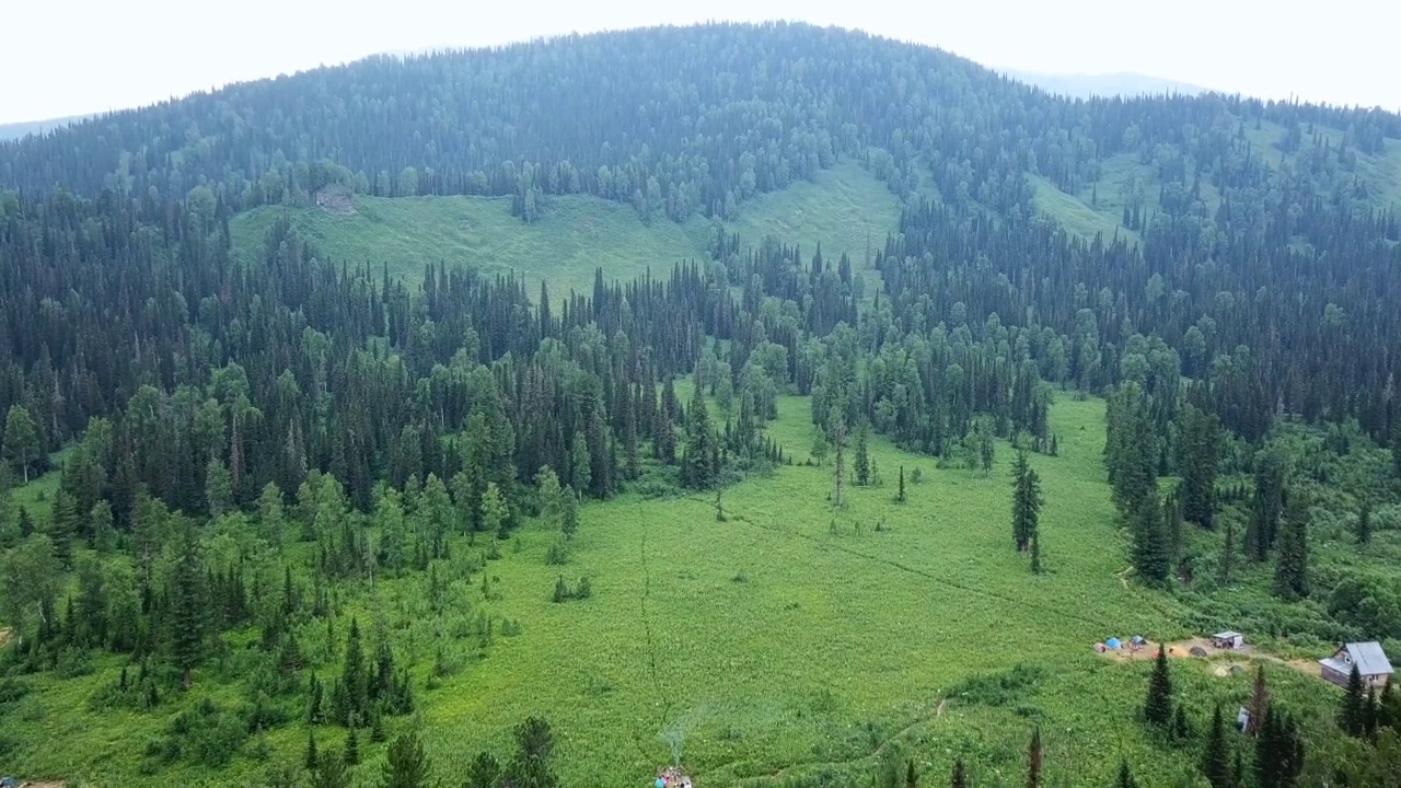 空中拍摄的小山上的针叶林。无人机俯瞰一望无际的云杉森林，山川风光。视频素材