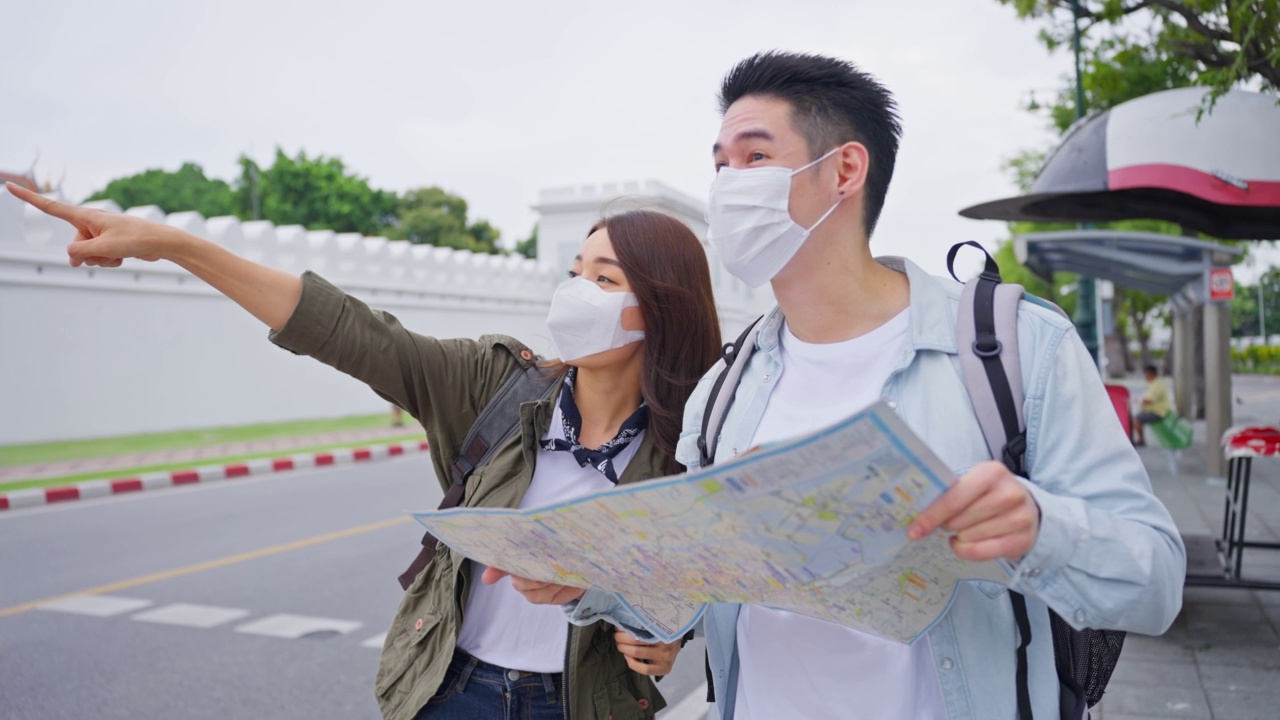 亚洲魅力情侣一起来这个城市度蜜月。年轻的新婚男女背包客为了预防新冠肺炎，戴着口罩，在泰国度假。视频素材