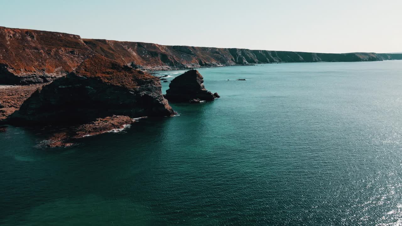 海洋海岸线上的岩石与蓝绿色的水和戏剧性的悬崖鸟瞰图。视频素材