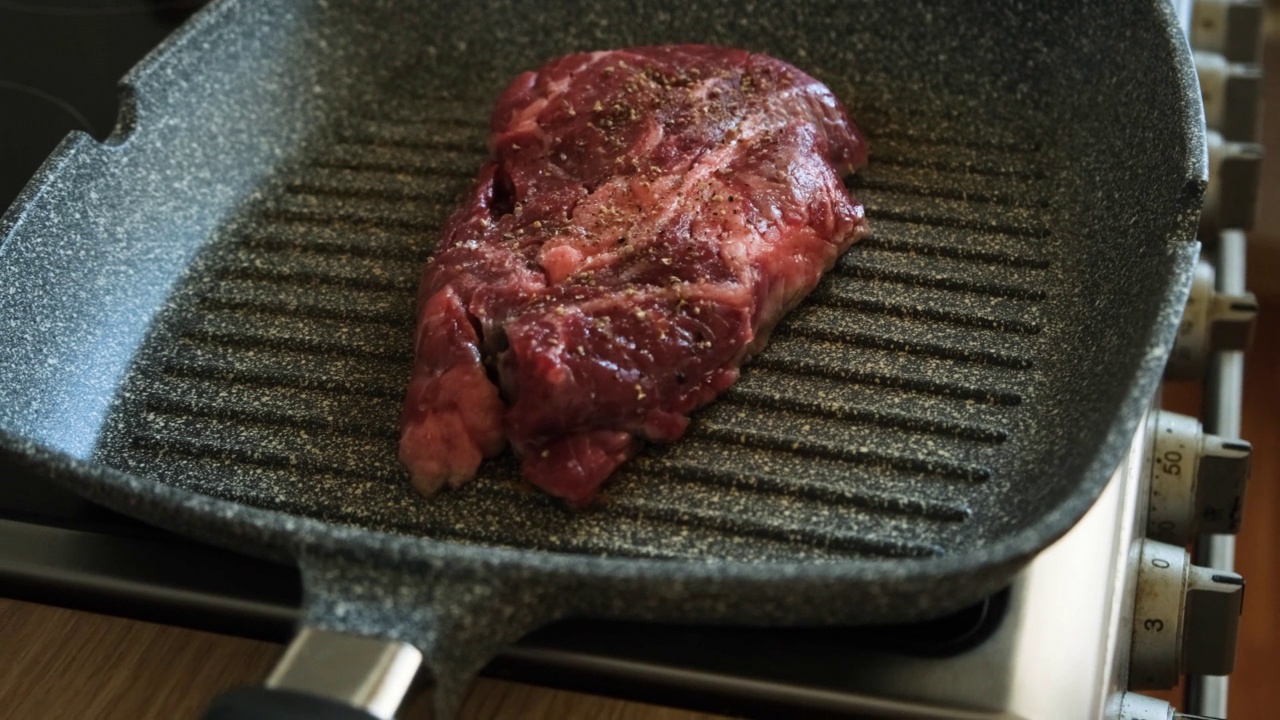 多汁的牛肉牛排在专业厨房的煎锅上烹饪。烤架上煎的上等牛排。美味的,现代的美食视频素材