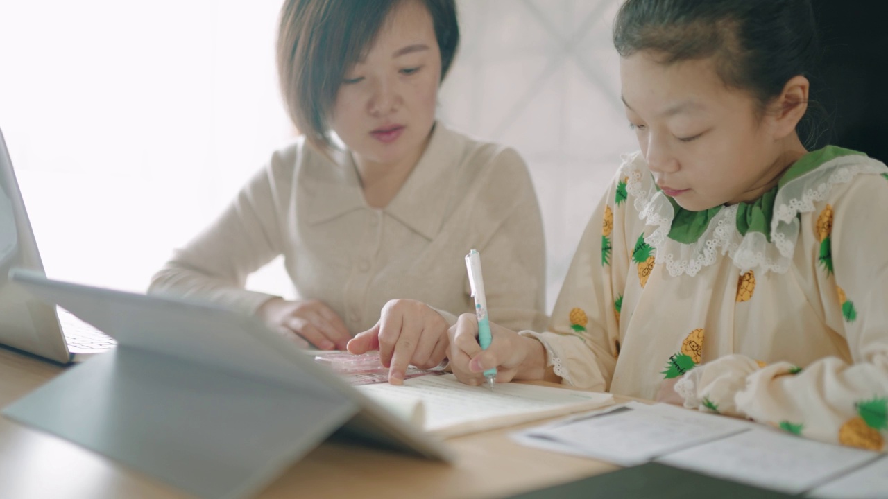 母亲在笔记本电脑上工作，孩子们在家在线上学。视频素材