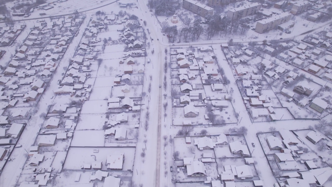 冬季鸟瞰图，雪村有私人住宅和花园地块视频素材