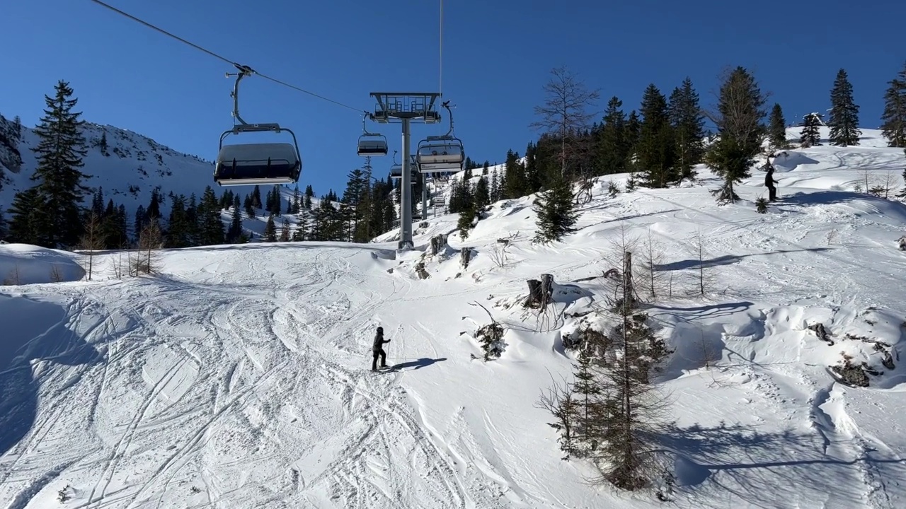 在阳光明媚的一天，从滑雪缆车到高山滑雪坡视频素材