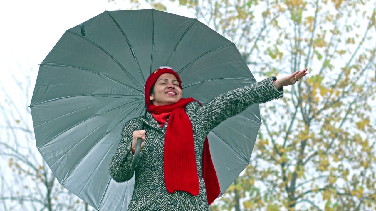 在雨季户外享受降雨的女人视频素材