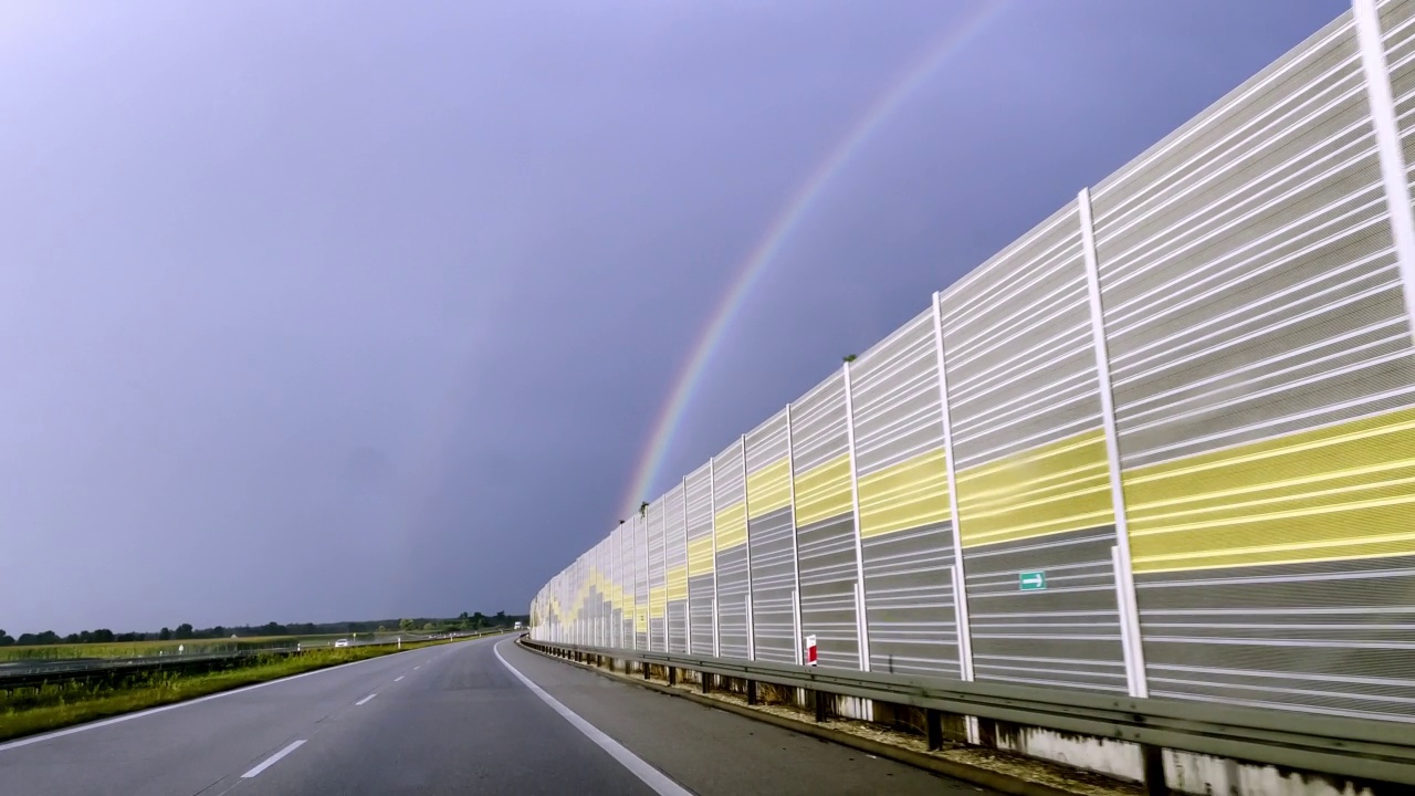 观点汽车驾驶。在雨中追逐彩虹视频素材