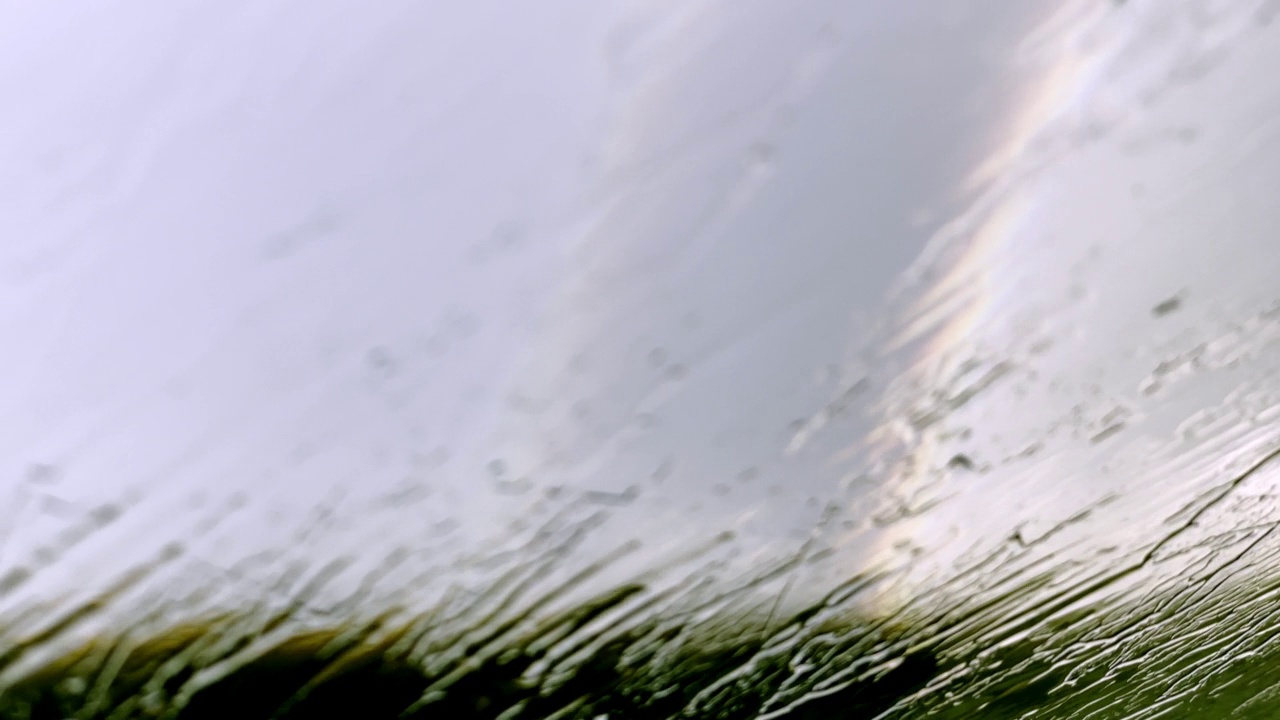 观点汽车驾驶。在大雨中追逐彩虹视频素材