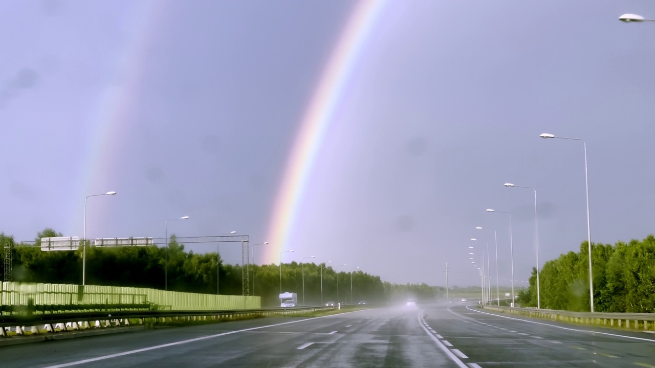 观点汽车驾驶。在雨中追逐彩虹视频素材