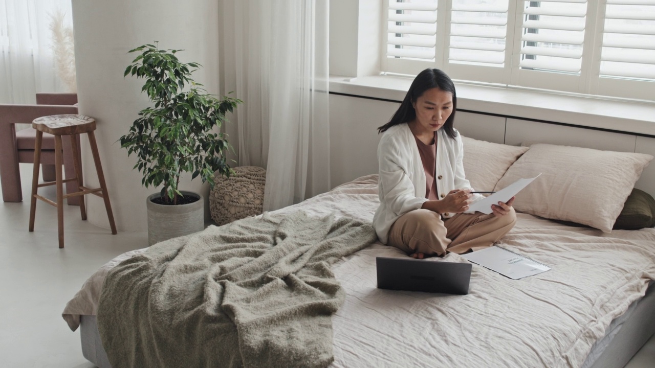 女人在床上处理文件视频素材