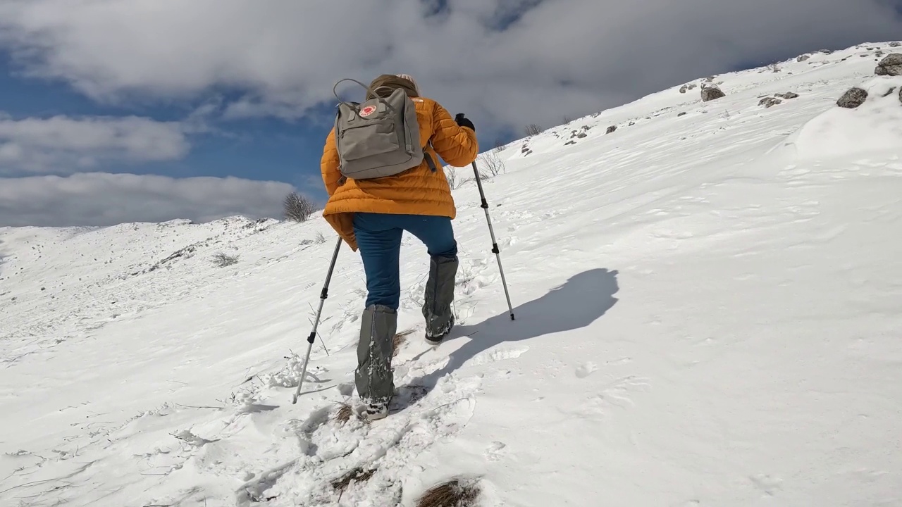 女徒步者攀登雪山视频素材