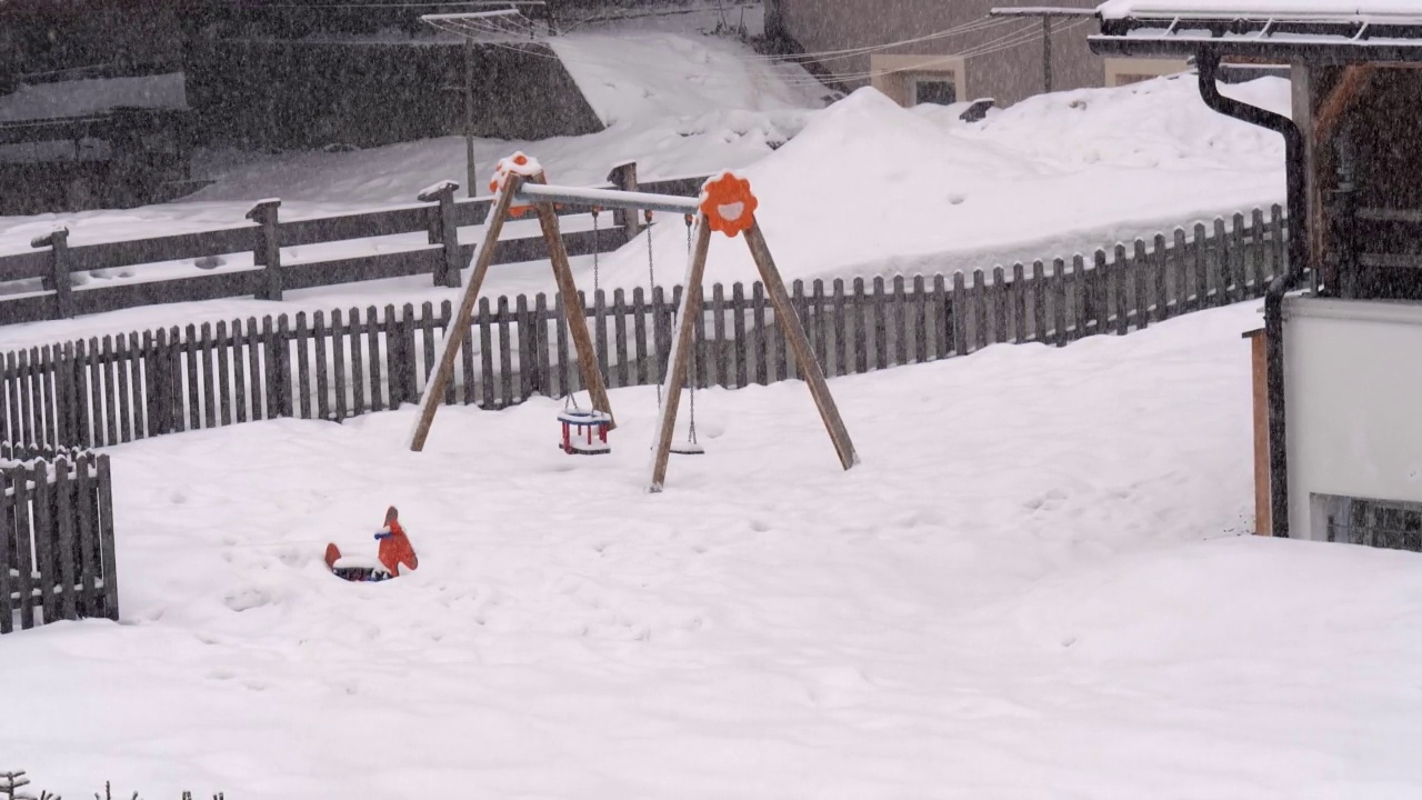 花园里正在进行的大雪与秋千和其他儿童游戏视频素材