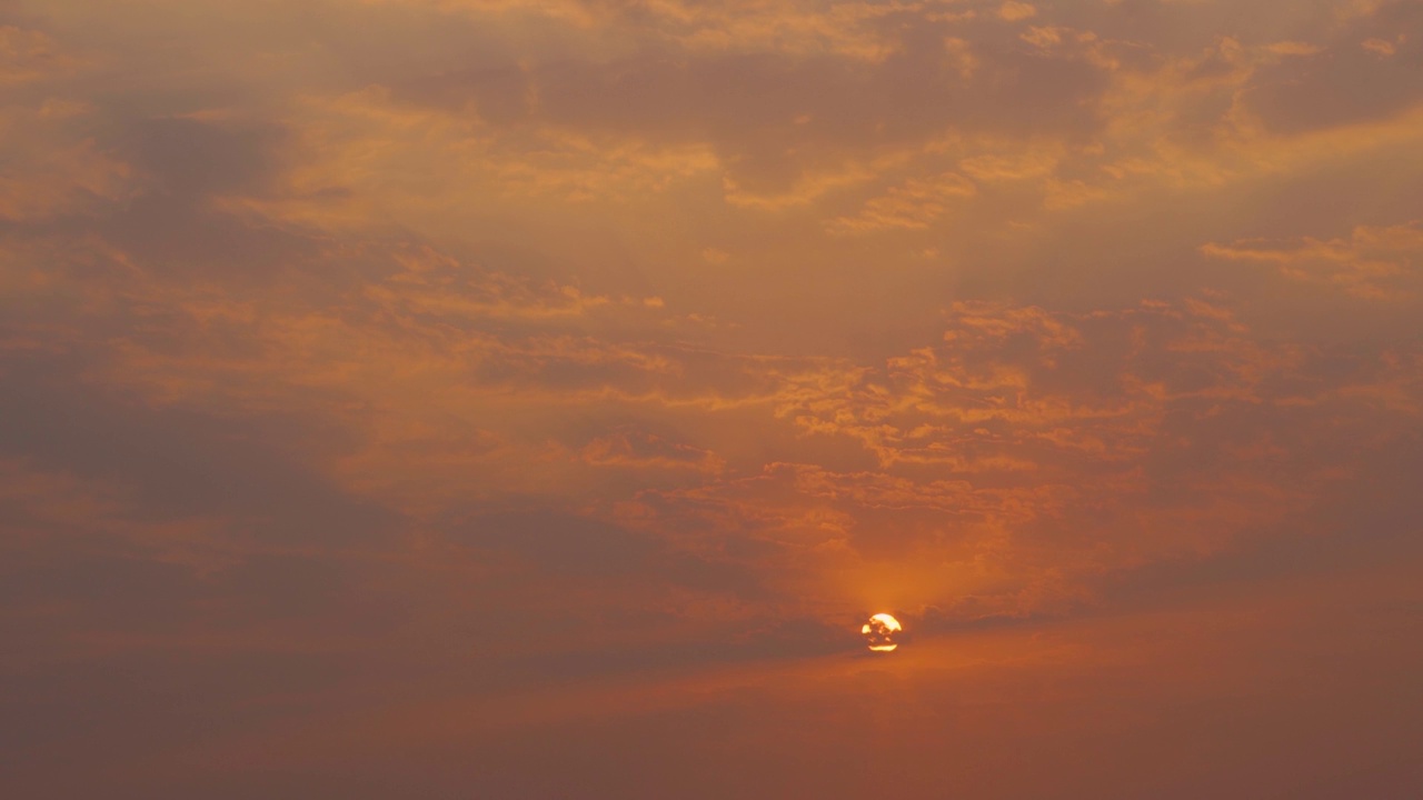 日落时太阳在云后的4K镜头。夕阳下的太阳。日落的自然背景视频素材