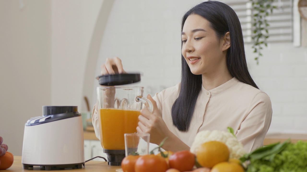 美丽的亚洲女人在家里喝水。保健和饮食的概念。视频素材