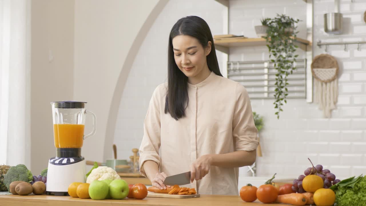 漂亮的亚洲女人在厨房做饭。保健和饮食的概念。视频素材