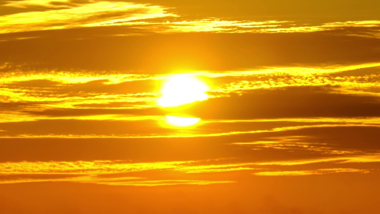 天空中的夕阳透过黄色的层叠云，时间流逝视频素材