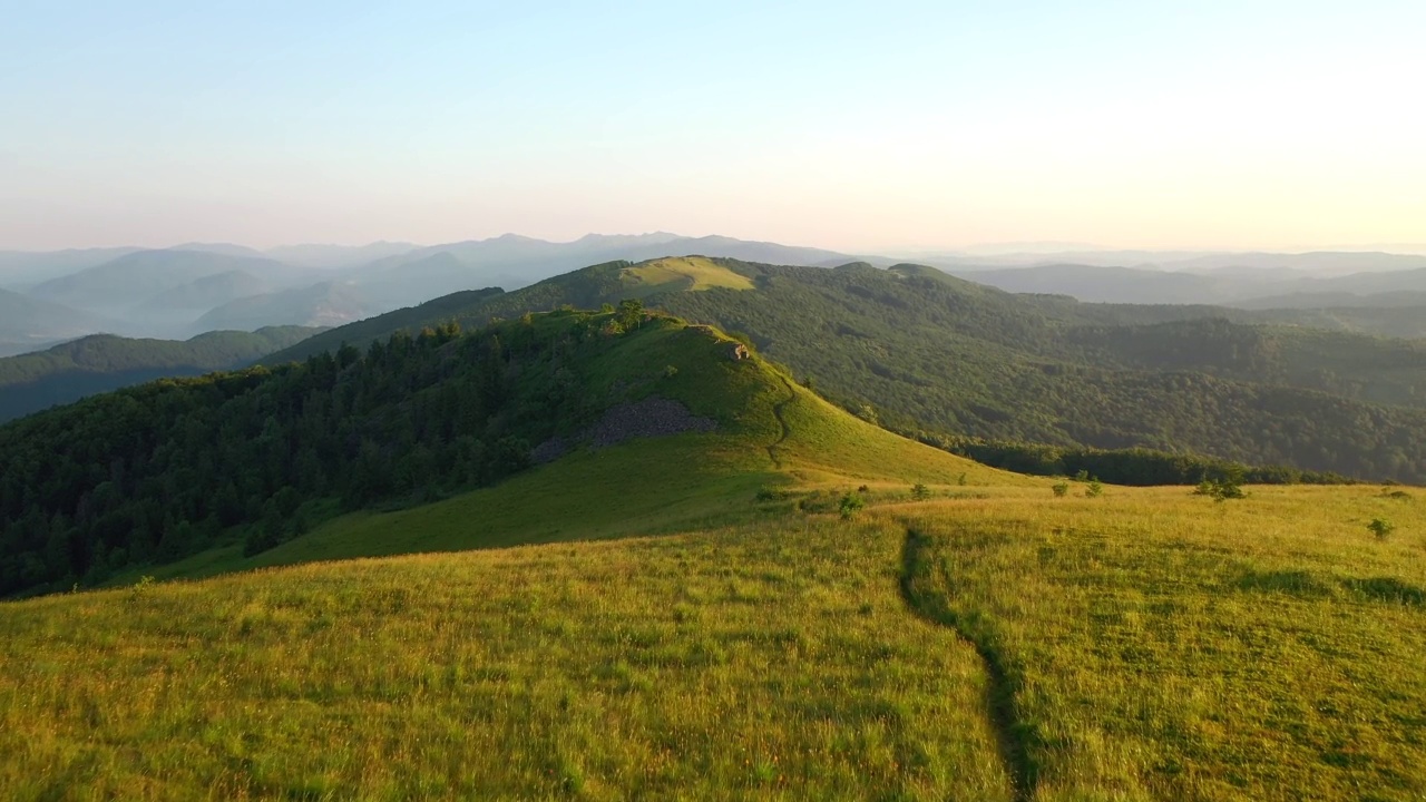 从一架四轴飞行器上拍摄高山高地上的绿色草地。视频素材