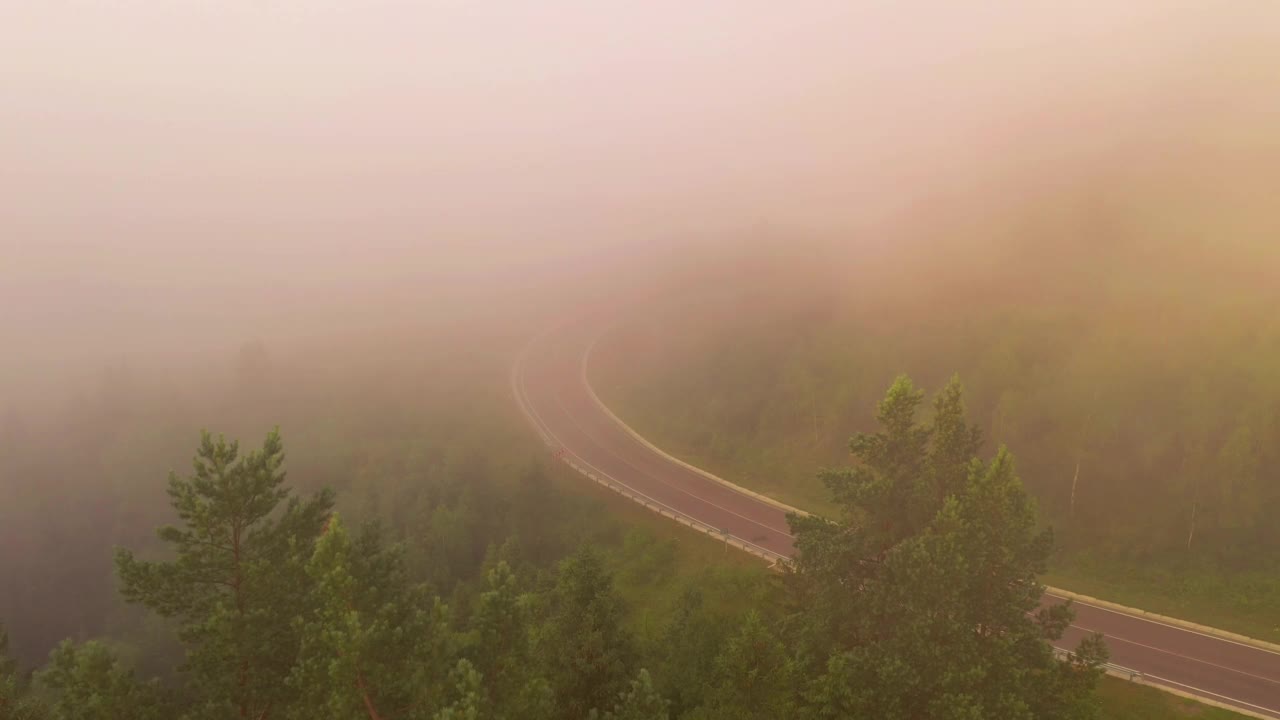 无人机飞过公路，消失在浓雾中。视频素材