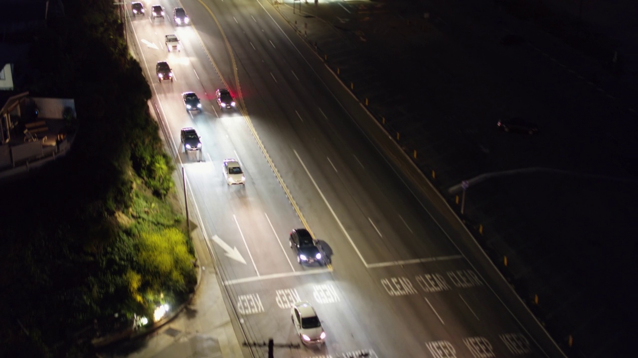 空中拍摄的照明车辆在道路上移动，无人机在风景上的植物上向后飞行-圣莫尼卡，加利福尼亚视频素材